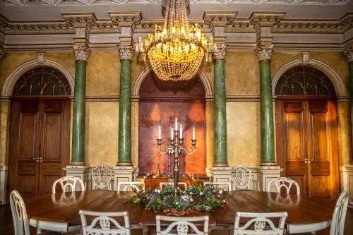 a dining room with a table and a chandelier at Fuglsang Herregaard Hotel in Nykøbing Falster