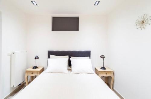 a bedroom with a white bed with two night stands at COZY APARTMENT IN BRUSSELS in Brussels