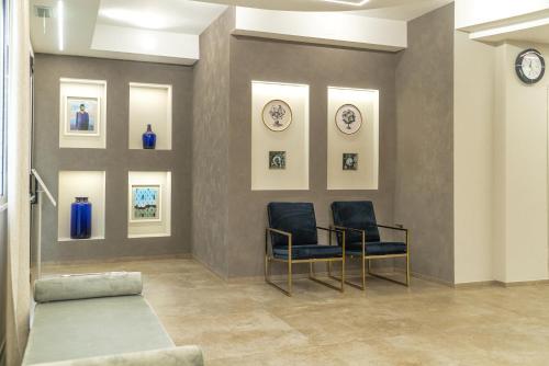 a waiting room with two chairs and clocks on the wall at Club Meeting Hotel in Rimini