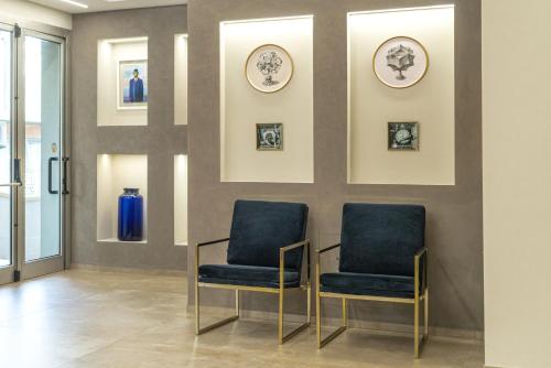 two chairs in a waiting room with pictures on the wall at Club Meeting Hotel in Rimini