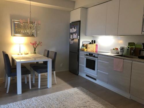 a kitchen with a white table and a white table and chairs at Lake view Helmi in Jyväskylä