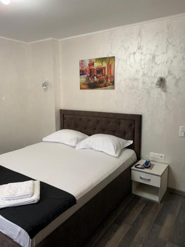 ブライラにあるPensiunea Adrianoのベッドルーム1室(ベッド1台付)が備わります。壁には絵画が飾られています。