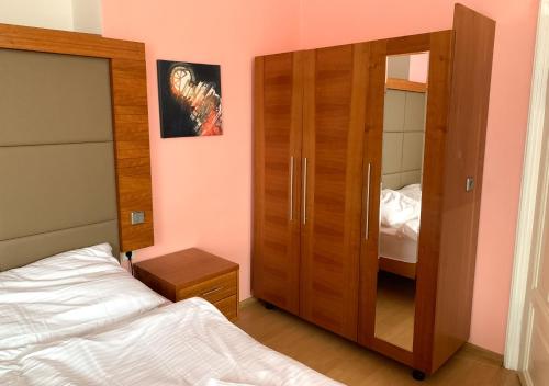 a bedroom with a wooden closet and a bed at Penzion Mlýnický Dvůr in Červená Voda