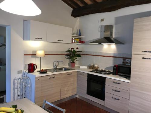 a kitchen with white cabinets and a stove top oven at Appartamento Il Glicine in Pistoia