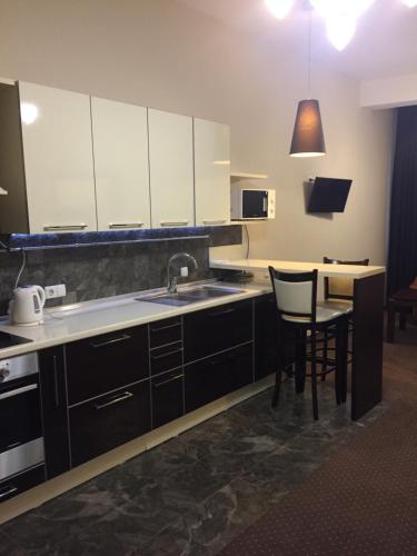 a kitchen with white cabinets and a sink and a table at Hotel-Restaurant Complex Vensky in Brovary