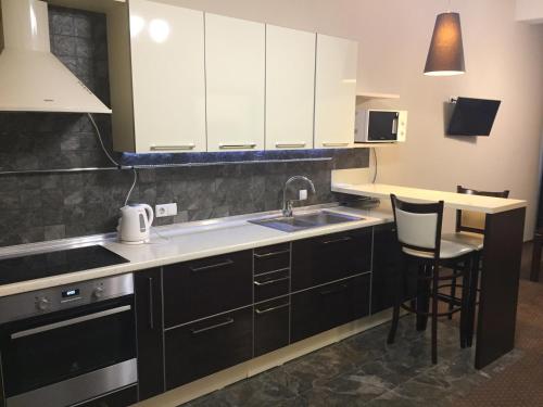 a kitchen with white cabinets and a sink at Hotel-Restaurant Complex Vensky in Brovary