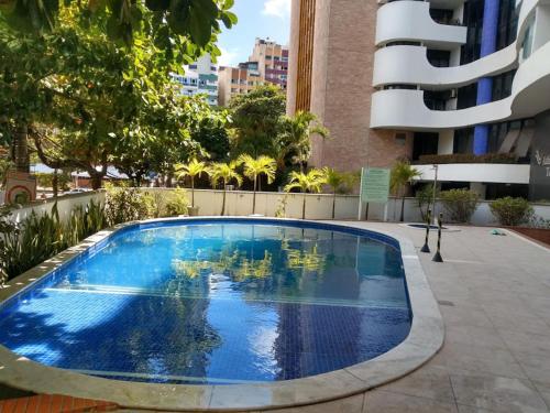 a large swimming pool in the middle of a building at Studio perto do Cristo carnaval circuito ondina in Salvador