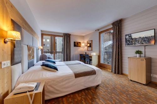 a hotel room with a large bed and a window at La Galise in Val dʼIsère