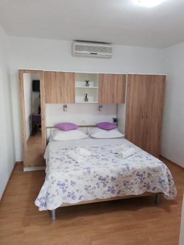 a bedroom with a large bed with purple pillows at Studio za 2 osobe- LIJANA in Tučepi