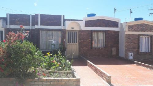 een stenen huis met een deur en wat bloemen bij Casa Adelita Paraíso Azul in Aquitania