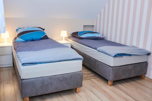 two beds sitting next to each other in a room at Piaskowe Domki in Grzybowo
