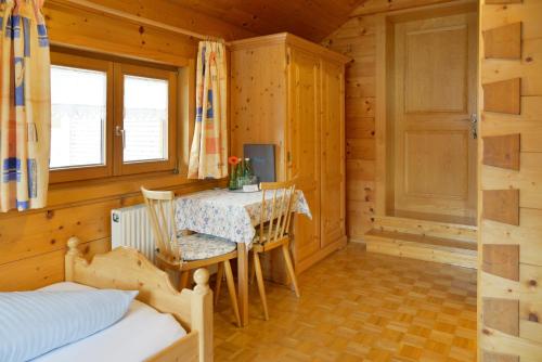 um quarto com uma mesa e uma cama e um quarto em Pension Haus Romy em Schoppernau