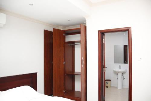 a bedroom with a bed and a mirror and a sink at Kenlon Hotel Kampala in Kampala