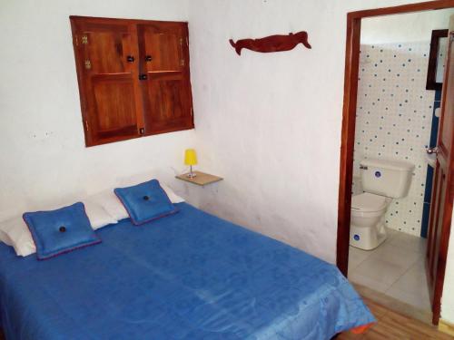 ein Schlafzimmer mit einem blauen Bett und einem WC in der Unterkunft Hostal Encanto La Salada in Jardin
