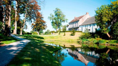a house and a canal in front of a house at Hotel Golf de Pierpont in Bons Villers