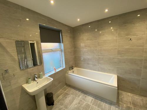 Un baño con bañera, lavabo y bañera. en Heaton Park Road Professional Lets, en Newcastle