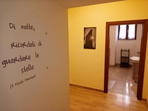 una habitación con una pared con escritura en la pared en L'Antico Monastero, en SantʼAgata di Puglia