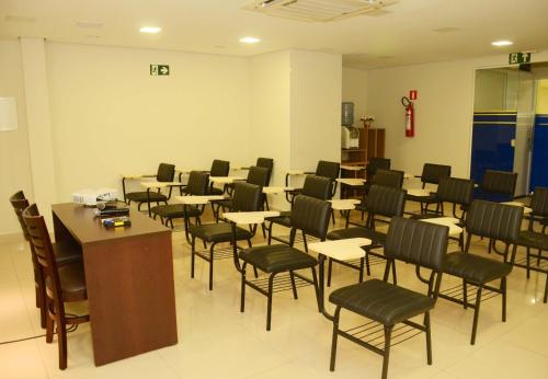 a waiting room with tables and chairs in a building at Hotel Palace Santarém Brasil in Santarém