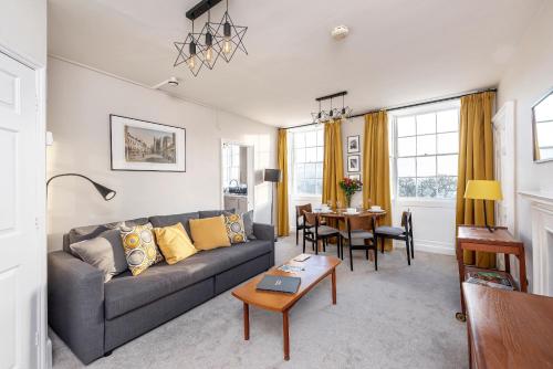 una sala de estar con un sofá y una mesa en Abbey View, en Bath
