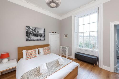 a white bedroom with a bed and a window at Park View Ground Floor 1 Bed Apt in Bath
