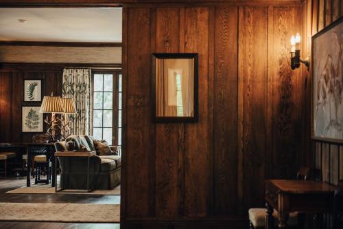 a living room with wood paneled walls and a couch at The Greystone Inn in Lake Toxaway