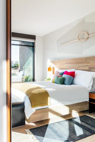 a bedroom with a large bed and a mirror at Hotel San Luis Obispo in San Luis Obispo