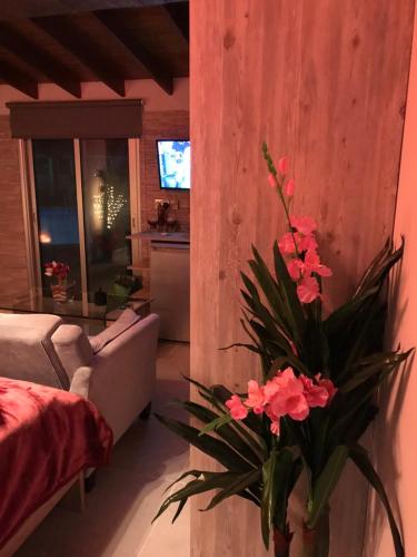 a living room with a couch and a vase with flowers at SOFROS VALLEY HILLS CHALET in Ayios Mamas
