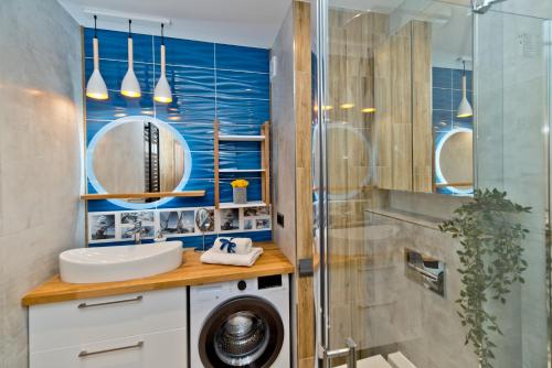 a bathroom with a sink and a washing machine at BlueApart Apartamenty Na Klifie in Władysławowo