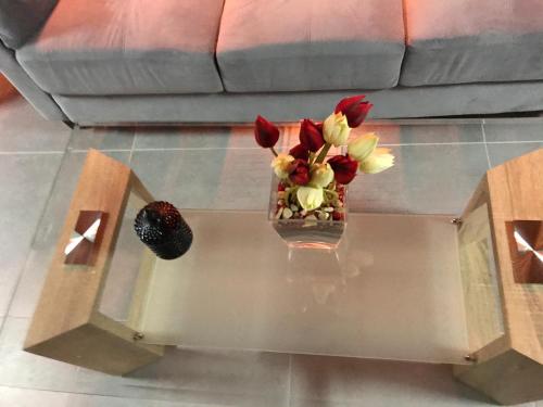 a vase of flowers sitting on a glass table at SOFROS VALLEY HILLS CHALET in Ayios Mamas