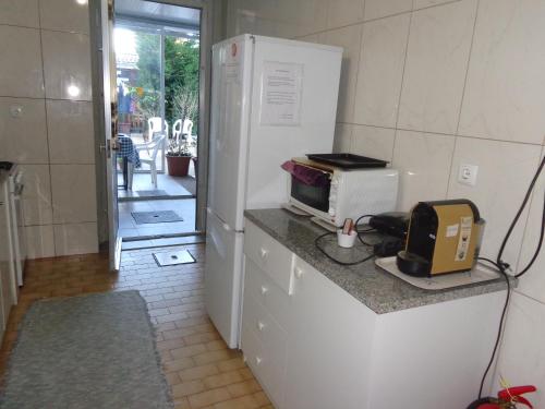 a kitchen with a counter with a microwave and a refrigerator at Portuense Alojamento Local in Porto