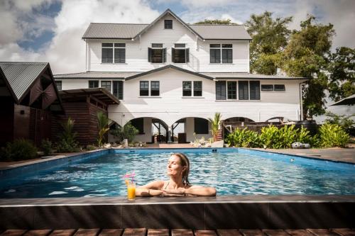 a woman laying in a swimming pool in a house at Boutique Hotel Peperpot in Meerzorg