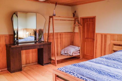 ein Schlafzimmer mit einem Spiegel, einem Bett und einem Tisch in der Unterkunft Viesu nams Jaunzilakši in Vireši