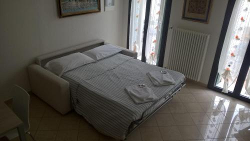 a bedroom with a bed with two towels on it at Casa Cuore - Love Pets - Fronte Ospedale Sacro Cuore in Negrar