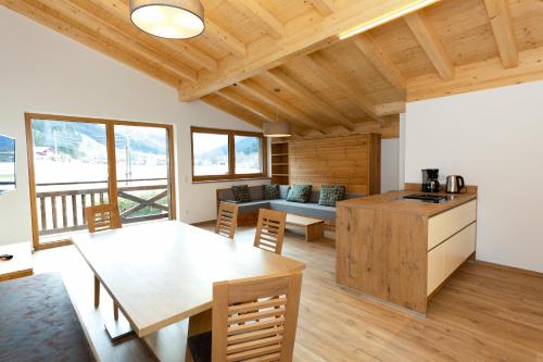 a kitchen and living room with a wooden ceiling at Juche! Ferienwohnungen in Kleinarl