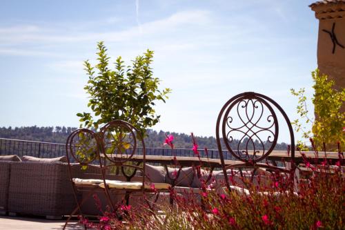 a bench sitting in a garden with pink flowers at Bastide Saint Maurin in Ansouis