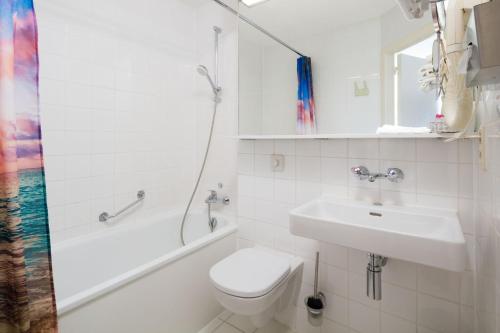 uma casa de banho com um WC, um lavatório e um chuveiro em Vivaldi Hotel em Westerlo