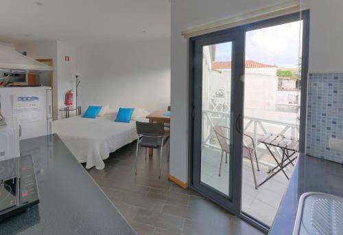 eine Küche mit einem Zimmer mit einem Bett und einem Balkon in der Unterkunft Faial Marina Apartments 1 in Horta