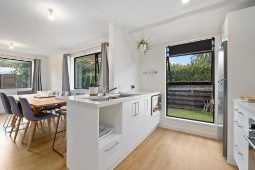 a kitchen and dining room with a table and chairs at Rees on Reid - Arrowtown Holiday Home in Arrowtown