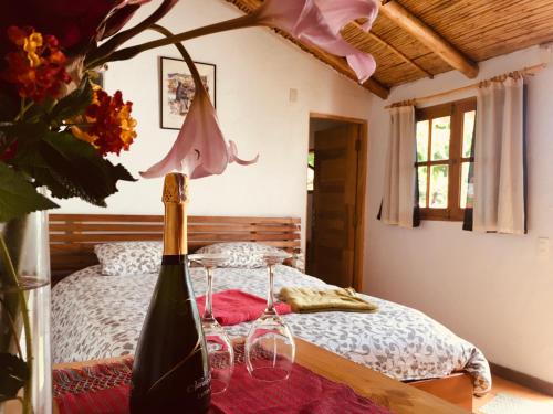 um quarto com uma cama e uma garrafa de vinho em La Selenita em Sucre