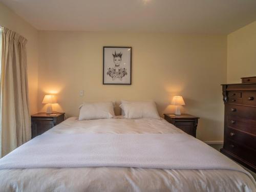 a bedroom with a large bed with two lamps at Rue Noyer Lookout - Akaroa Holiday Home in Akaroa
