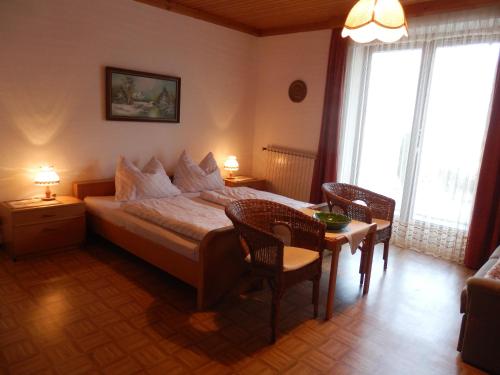 a bedroom with a bed and a table and chairs at Ferienhaus Maier in Lind