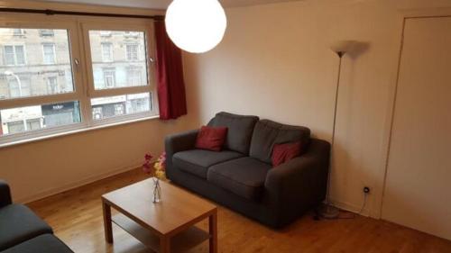 a living room with a couch and a table at Beautiful king room in Leith Walk in Edinburgh