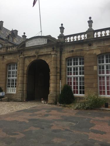 a building with two dogs sitting outside of it at Augustodun'Home in Autun