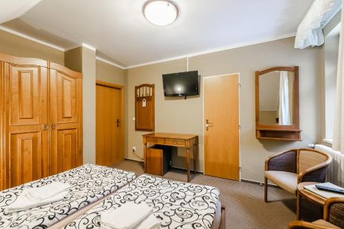 a hotel room with a bed and a desk at Hotel Perla Jizery in Josefuv dul