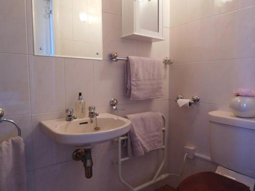 a white bathroom with a sink and a toilet at The Castle B&B in Inverness
