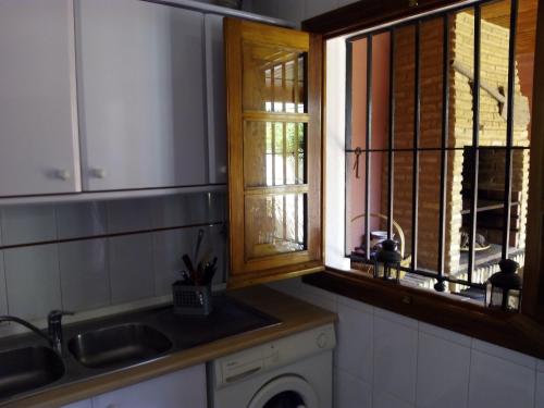 uma cozinha com um lavatório, uma janela e uma máquina de lavar roupa em Sol y Mar em Isla Cristina