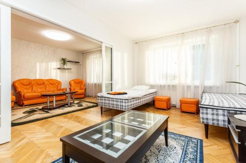 3 room central apartmend 90m2 parking for one car في تالين: غرفة معيشة مع كراسي برتقالية وأريكة