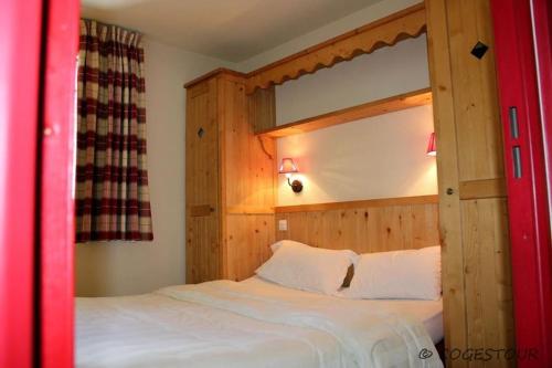 a bedroom with a large white bed with a wooden headboard at Les Alpages de Val Cenis 3p 6p in Lanslebourg-Mont-Cenis