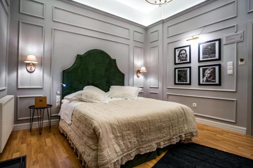 a bedroom with a large bed with a green headboard at Esperia Boutique Hotel in Agrinio