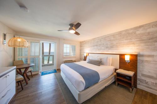 a bedroom with a bed and a table and a desk at SeaCrest Oceanfront Hotel in Pismo Beach